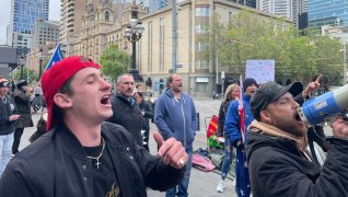 Protesters outside Melbourne’s Parliament house. A reverse baseball cap helps validate one’s point of view. A gent with a bullhorn without a bull in sight.