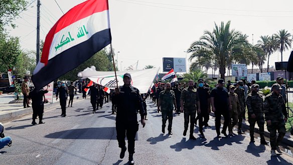 Iran-backed militia fighters march in central Baghdad, Iraq in June.