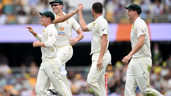 Josh Hazlewood, Pat Cummins and Cameron Green, along with Marnus Labuschagne, celebrate a wicket at the Gabba.