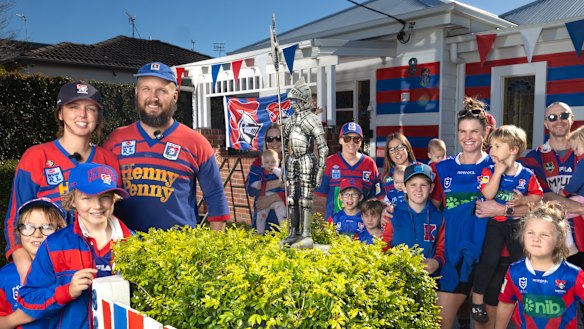 Teigan and Sam Jobbins, left, with their daughter Alfie, 7, and son George, 9, are joined by other Newcastle Knights supporters at their New Lambton home.