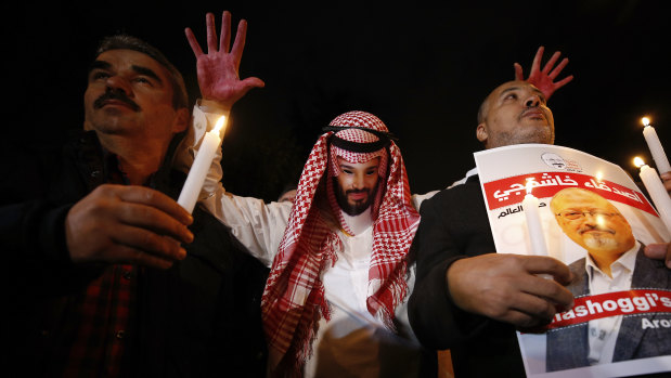 An activist wearing a mask depicting Saudi Crown Prince Mohammed bin Salman holds up his hands, painted with fake blood, as he protests the killing of Saudi journalist Jamal Khashoggi in Turkey.