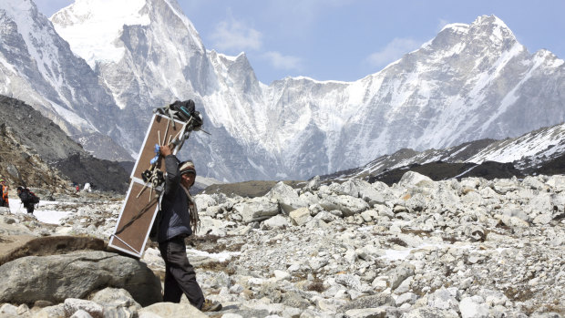 A porter carries crates containing oxygen tanks on his way towards Everest Base Camp.