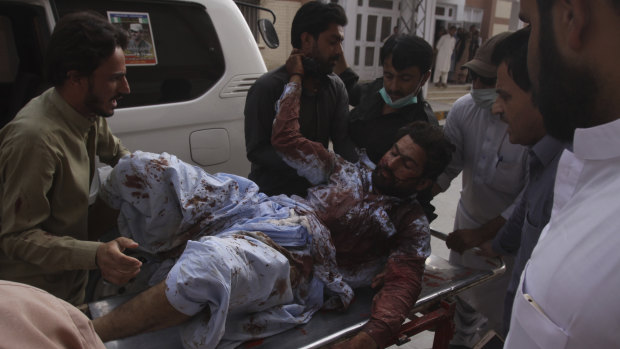 People rush an injured person to a hospital in Quetta, Pakistan after Friday\'s bombing.