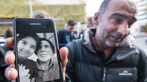Yama Nabi holds a photo of his father Haji-Daoud Nabi who was killed in the Al Noor Mosque in Christchurch.