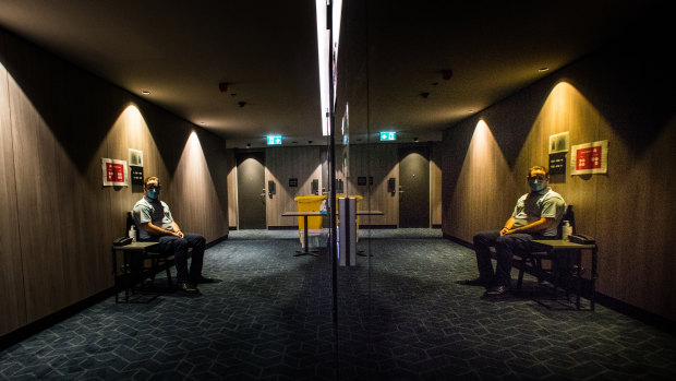 A quarantine support officer at his station near the lifts at the Four Points hotel. It is hotel ventilation systems that most worry those in the medical and occupational health fields pushing for change.