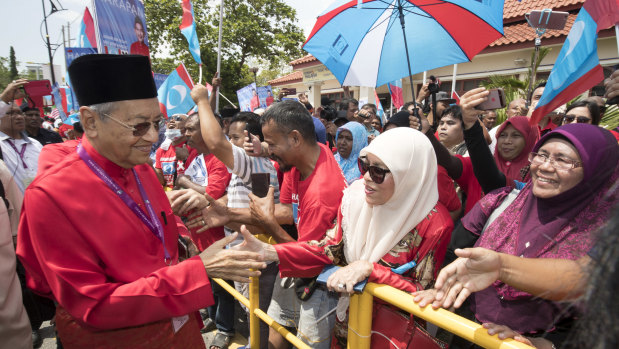 Former Malaysian strongman Mahathir Mohamad shakes hands with his supporters after his nomination outside the nomination centre in Langkawi on Saturday.