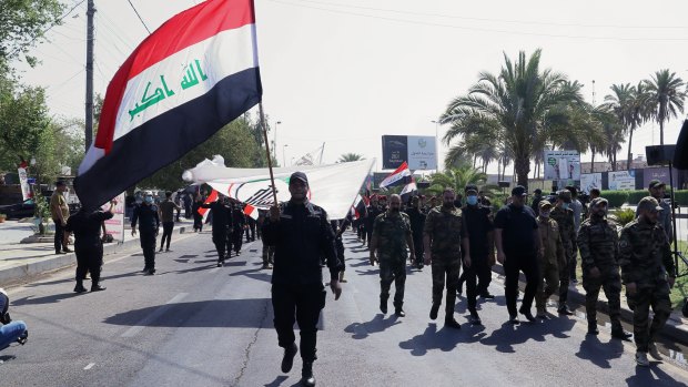 Iran-backed militia fighters march in central Baghdad, Iraq in June.