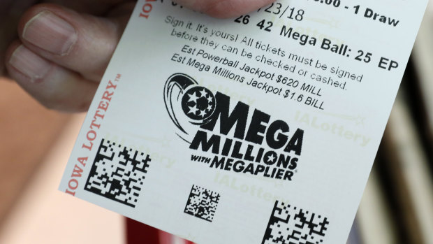 A customer shows his Mega Millions lottery ticket at a local grocery store in Des Moines, Iowa.
