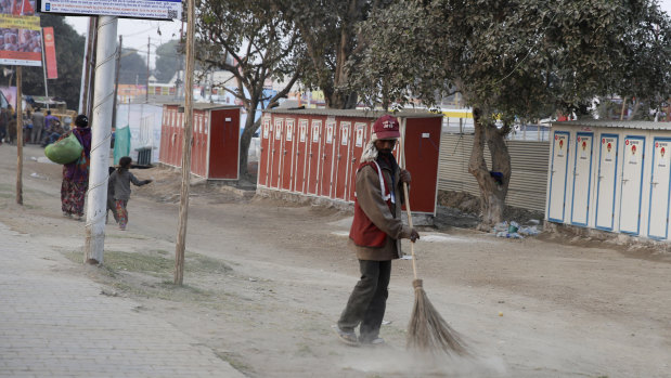 A municipal worker sweeps the streets near the festival's tent city, where public toilets and hundreds of water stations have been set up.