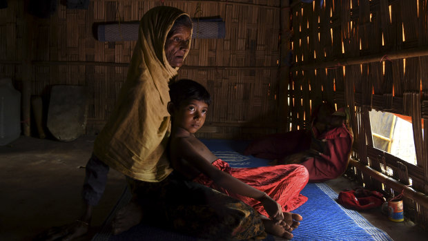 Subia Khatun, 60, holds her orphaned granddaughter Nuru Zannat aged 5 in their shelter in Kutupalong Camp, Bangladesh, in July.