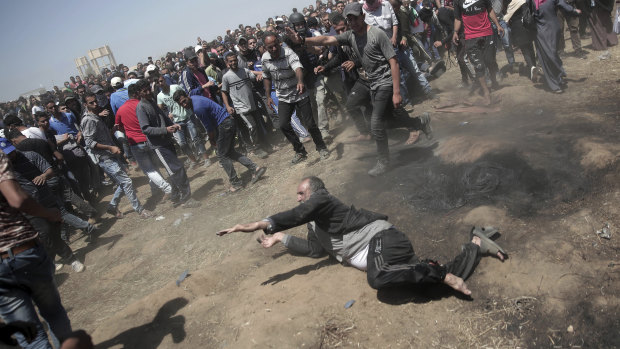 An elderly Palestinian man falls on the ground after being shot by Israeli troops.