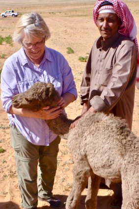 Michele Cotton with a baby camel and a Bedouin client in Aqaba, Jordan.