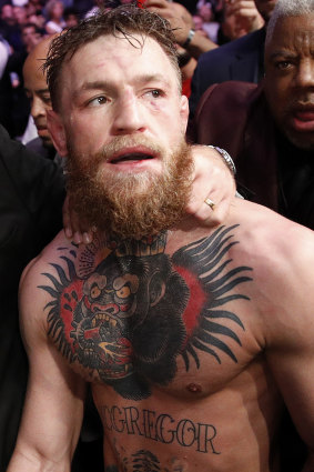 Stunning conclusion: Conor McGregor being led away by security after the post-fight drama.