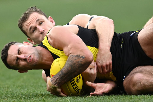 Joel Selwood lays a tackle on Jack Graham.