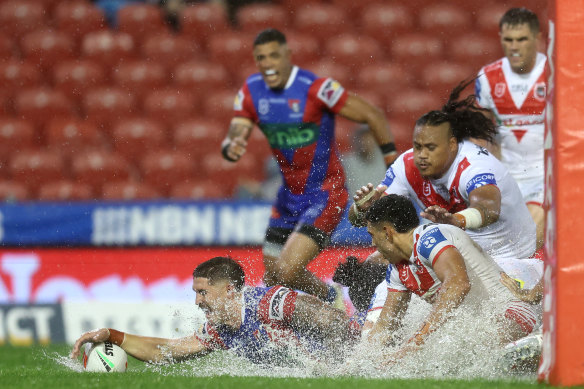 Dylan Lucas scores in the Newcastle slush for a try.