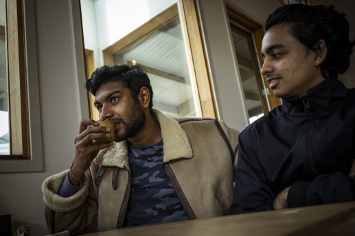 Shank Prasad (left) tries an edible cup with his chai as friend Harry Sridhar looks on.