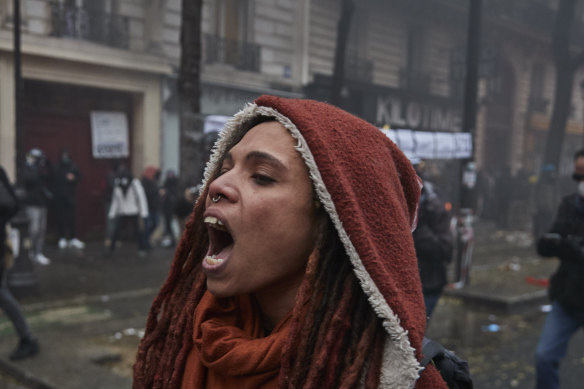 A protestor screams amidst clouds of tear gas and smoke.