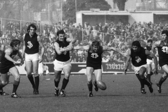 Fitzroy captain Kevin Murray [C] breaks through after the ball between Carlton’s Syd Jackson [L] and Sergio Silvagni [R] at Junction Oval. The famous fog game at Junction Oval.