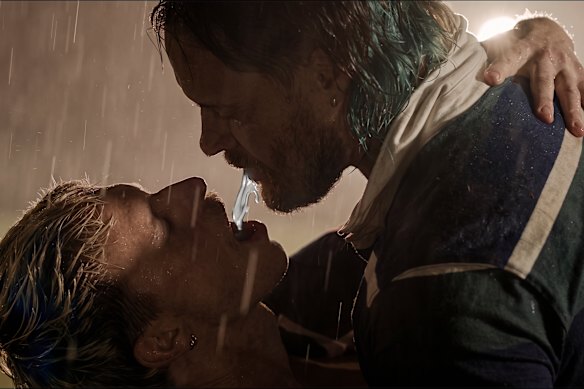 Brown spitting blue electrolyte drink into ANDY’s mouth.