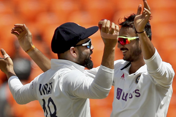 Axar Patel celebrates with captain Virat Kohli after the dismissal of Ben Stokes.