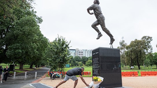 Cricket fans pay tribute at the statue of Shane Warne.