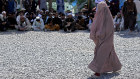 An Afghan woman in full body covering waits to receives food rations in Kabul last month.