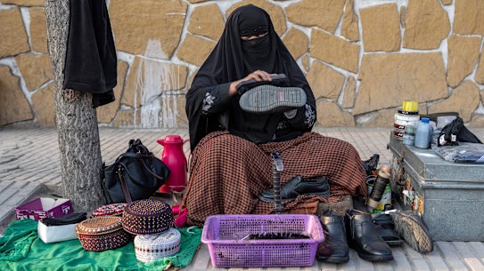 An Afghan woman cleans shoes in a street in Kabul, Afghanistan, last month. After the Taliban came to power in Afghanistan, women have been deprived of many of their basic rights.