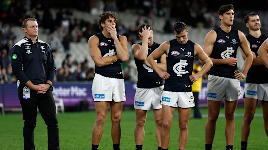 Carlton coach Michael Voss and his players look dejected after losing to the Magpies on Thursday night.