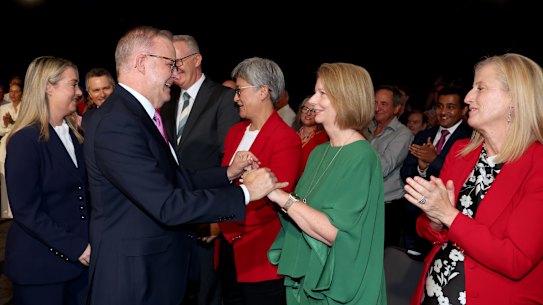Anthony Albanese shakes hands with Julia Gillard before taking the stage.
