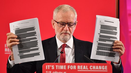 Labour leader Jeremy Corbyn brandishes documents he says prove the NHS is "up for sale". 