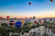 Hot air balloons hover over Cappadocia, Turkiye.