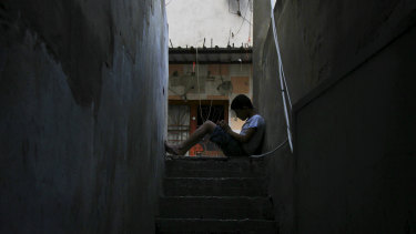 A boy reads on stairs in the Fatah area of Ain al-Hilweh.