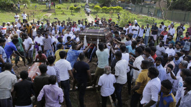 Sri Lankans prepare to bury the coffins carrying remains of Berington Joseph, left, and Burlington Bevon, who were killed in the Easter Sunday bombings.