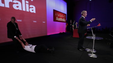 A protester is dragged off stage by security at Labor's national conference in Adelaide.