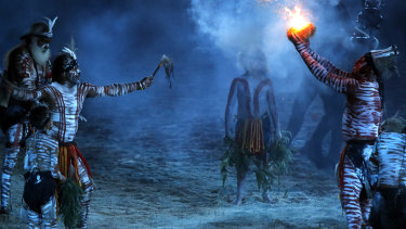 Indigenous dancers perform a smoking ceremony. 
