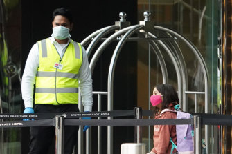 A security guard and a young traveller outside Melbourne's Crown Promenade Hotel in March.