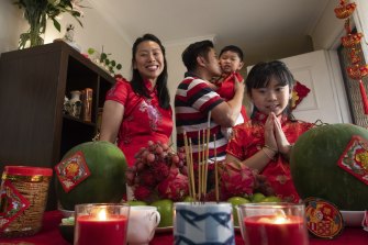 Michael Lau, his wife Wendy Tang and their two kids Kaitlyn, 9 and Austin, 2 praying at their Doncaster East home altar ahead of the lunar new year 