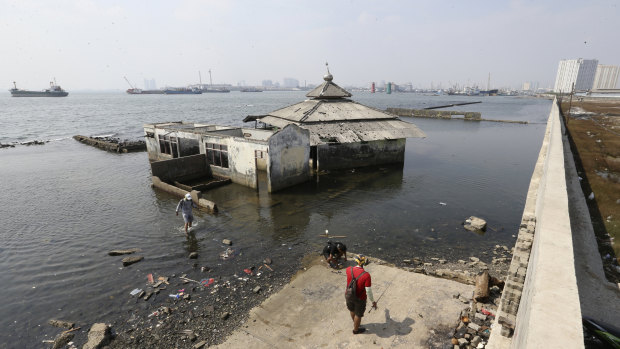 Sinking Jakarta: a former mosque lies outside a giant sea wall which is used as a barrier to prevent sea water flooding the city.