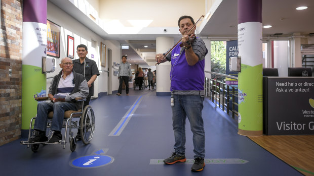Musical reception: volunteer Jozsef Tallosi plays in the Footscray hospital foyer.