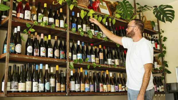 Madalenas owner Joel Rees straightens some wine.