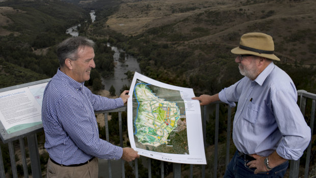 Riverview director David Maxwell, left, and consultant Tony Adam, at Shepherd's Lookout looking over the Murrumbidgee River and the area to the right to be developed for 11,500 homes and a conservation corridor. The pair, photographed in 2017, hold the development plan.