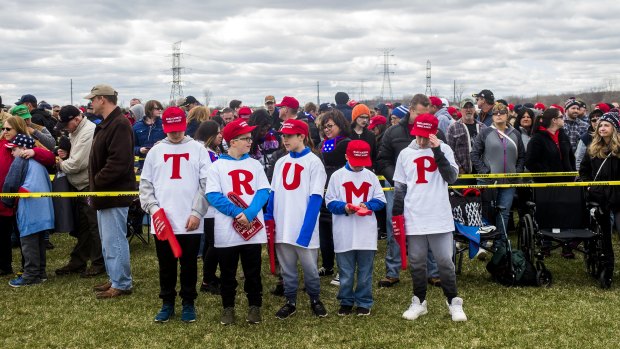 From left, Matthew Sakowski, Dylan King, Evan Sakowski and Bryce King spell out the letters "TRUMP" as they wait with other supporters to watch a Trump rally in Washington.