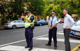 Assistant Commissioner Ben Marcus (centre) and Roads Minister Mark Bailey watching a routine speed camera operation outside Milton State School.