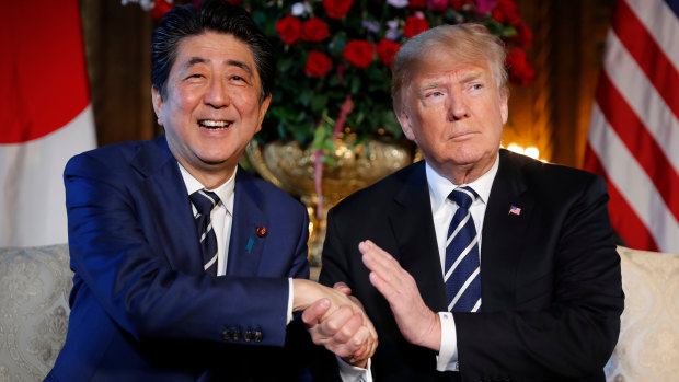 US President Donald Trump and Japanese PM Shinzo Abe speak during a meeting at Trump's private Mar-a-Lago club.