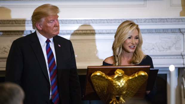 Pastor Paula White leads a prayer beside Donald Trump during a dinner celebrating Evangelical leadership in the State Dining Room of the White House.