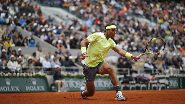 Spain's Rafael Nadal plays a shot against Switzerland's Roger Federer in the French Open semi-final in gusty conditions.