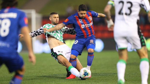 Timely intervention: Western's Tomislav Uskok defends bravely as Newcastle's Dimi Petratos surges forward.