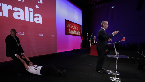 A protester is dragged off stage by security at Labor's national conference in Adelaide.