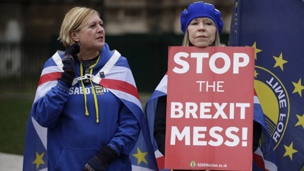 Anti-Brexit supporters hold placards outside Parliament on Monday.