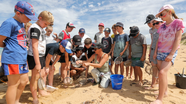 Colleen Hughson (centre) demonstrates how to collect nurdles to grade 6 students from Terang College. 